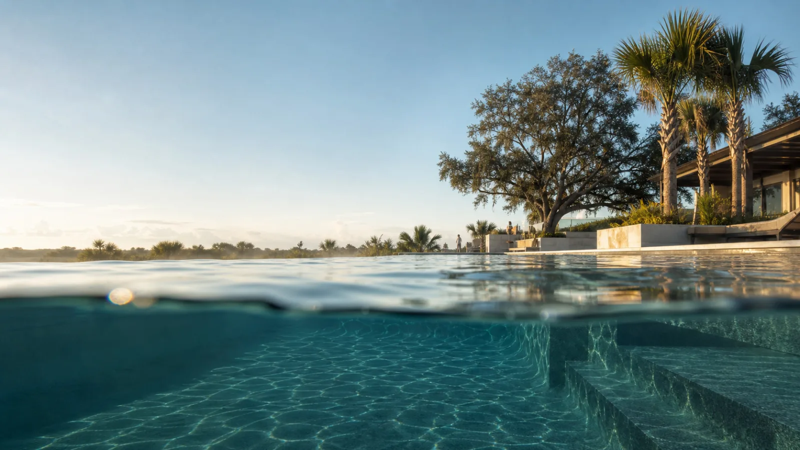 Piscina de borda infinita ao amanhecer, vista da linha da água